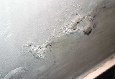Salts pushing off paint on a newly redecorated old damp wall
